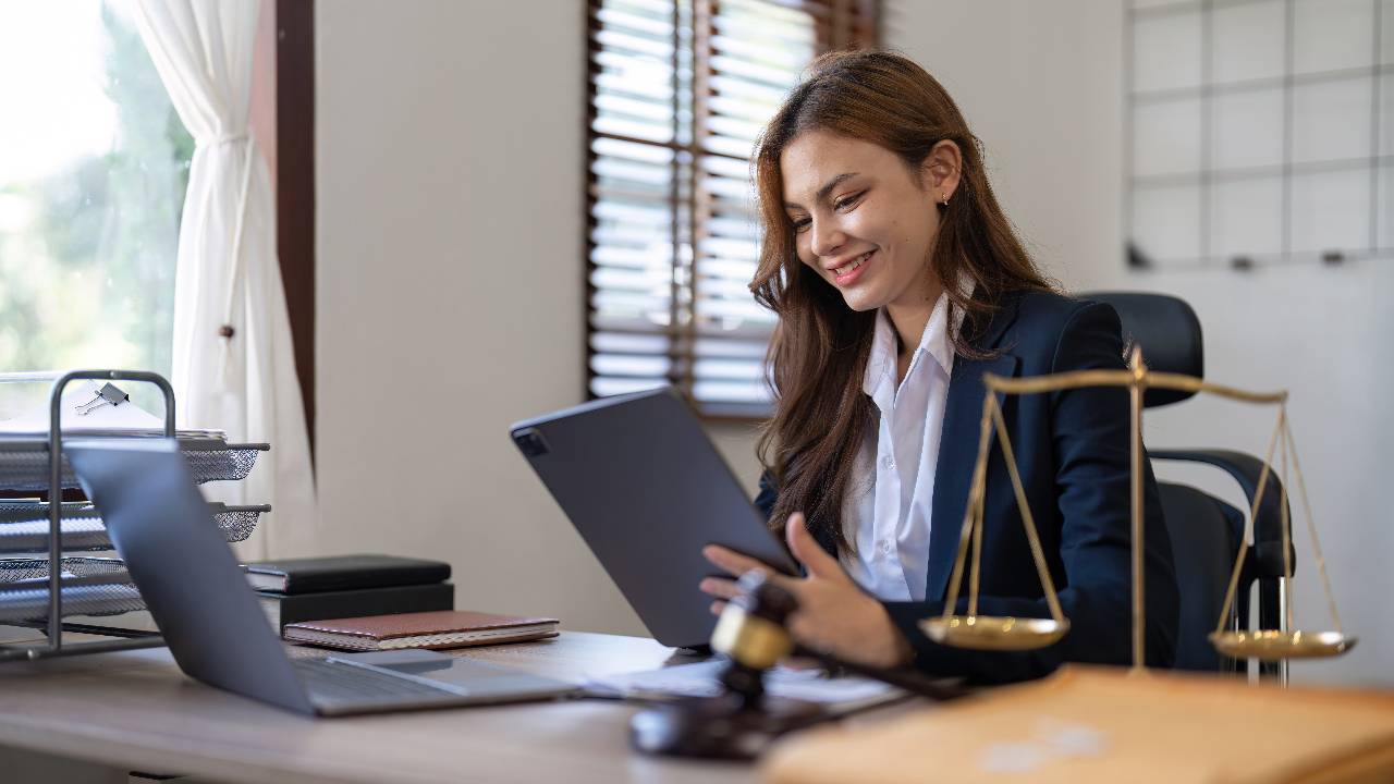Attractive young lawyer in office Business woman and lawyers discussing contract papers with brass scale on wooden desk in office