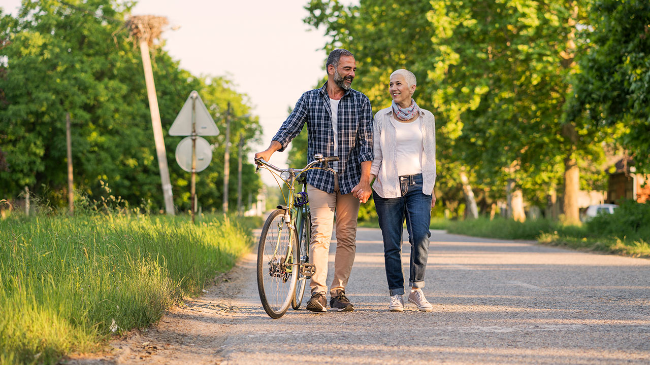 Couple walking while the man holding the bike