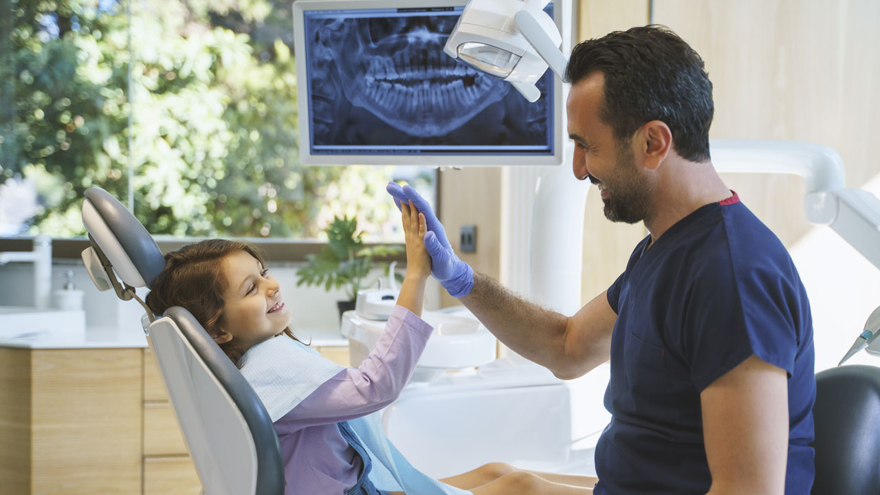 Dentist giving high-five to his patient